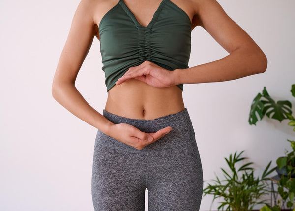A young lady with her hands on her stomach